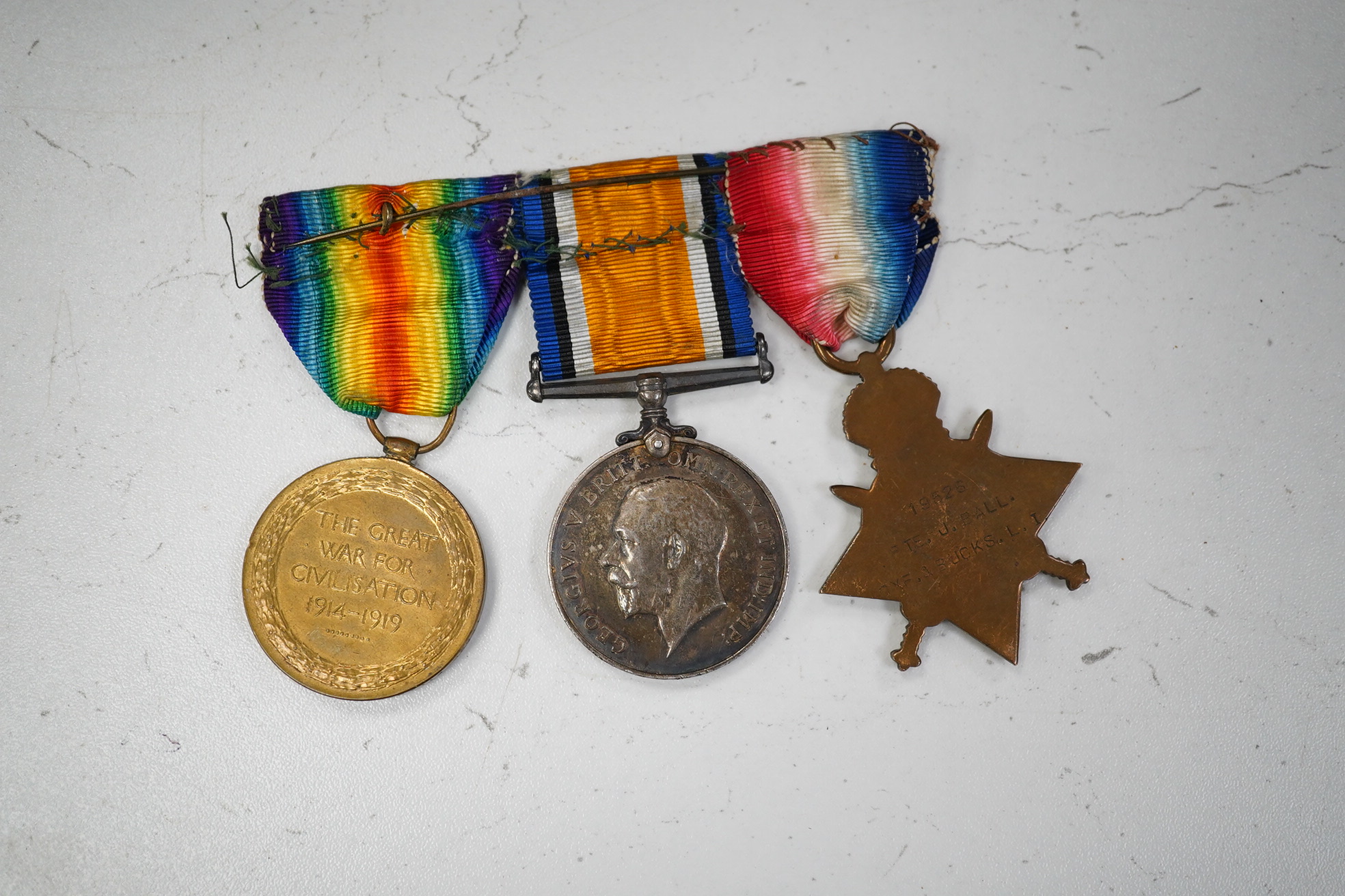 A First World War medal trio awarded to Pte. J. Ball Oxf. & Bucks. L.I., together with an oak mantle clock inset with a memorial plaque awarded to George John Ball, plus related paperwork. Condition - fair to good